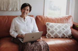 femme sur son canapé qui souscrit un prêt immobilier à 50 ans