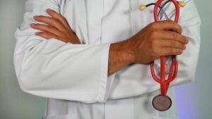 homme médecin avec un stéthoscope qui explique les risques aggravés en assurance emprunteur